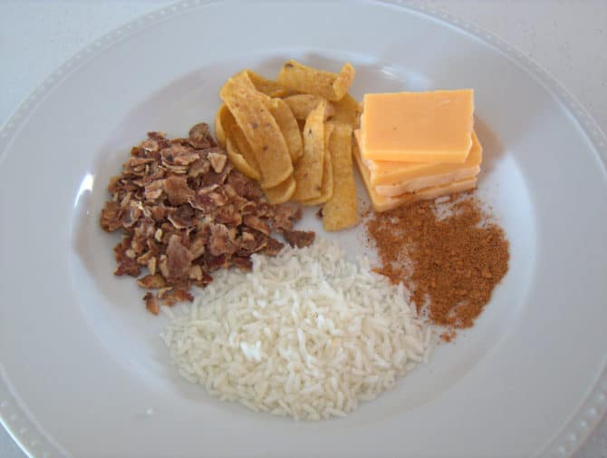 Clockwise from cheese in upper right: Cheese, taco seasoning, rice, refried beans, and Fritos