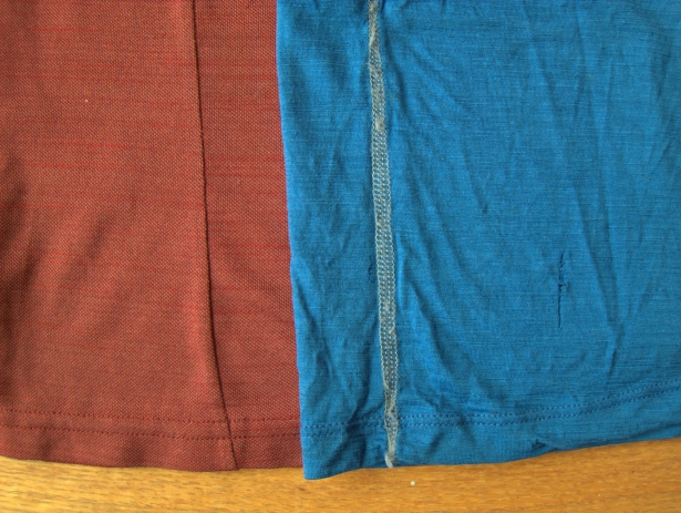 Closeup of a knit synthetic (red) and knit merino (blue). Each fabric type has pros and cons. Note the holes in the merino due to wear.