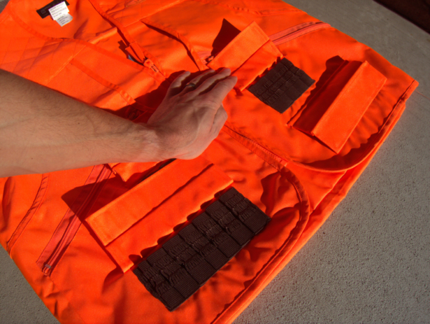 Each side of the vest has two sets of shell holsters, each covered with a flap.